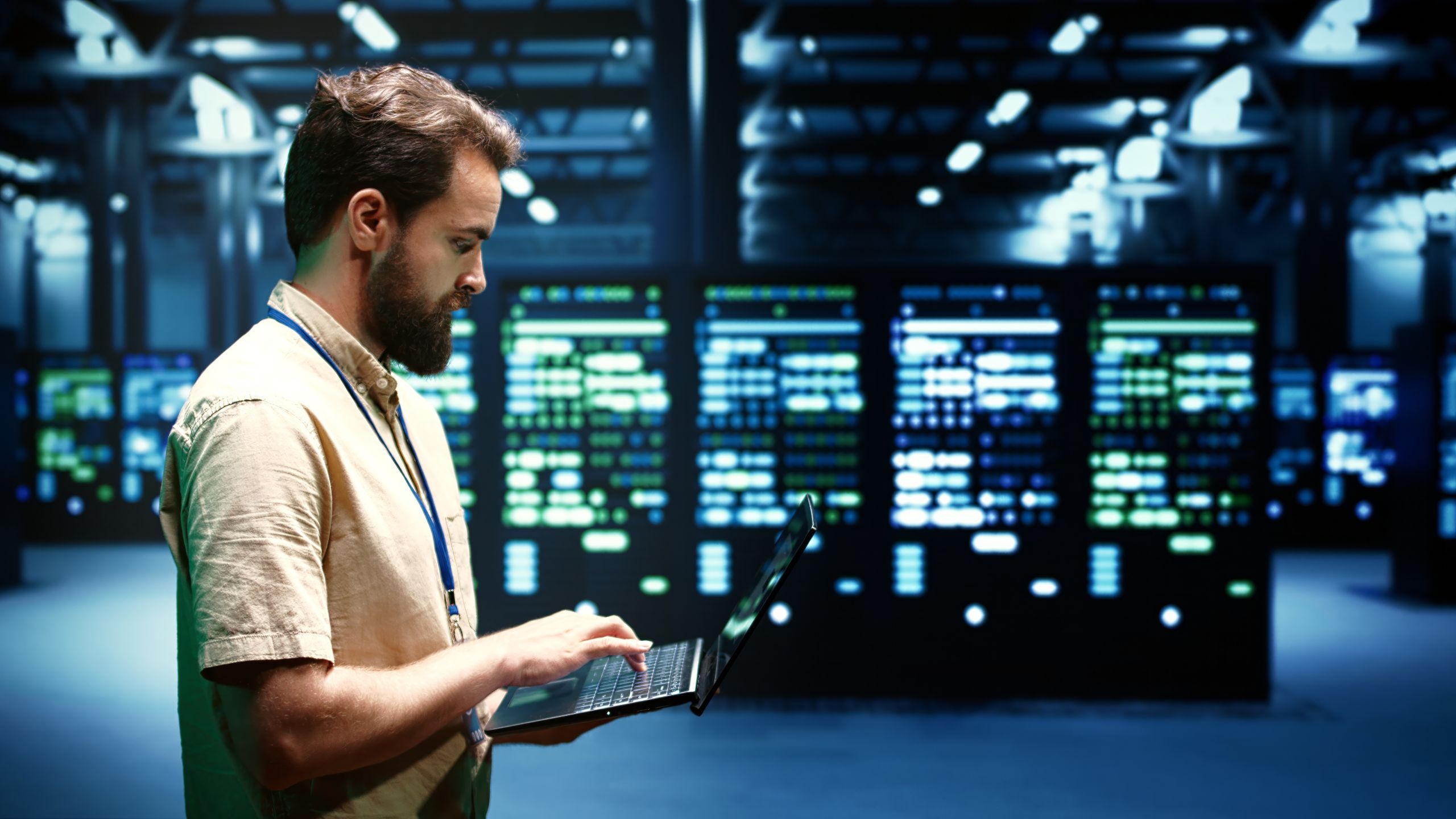 Engineer inside data center holding laptop.