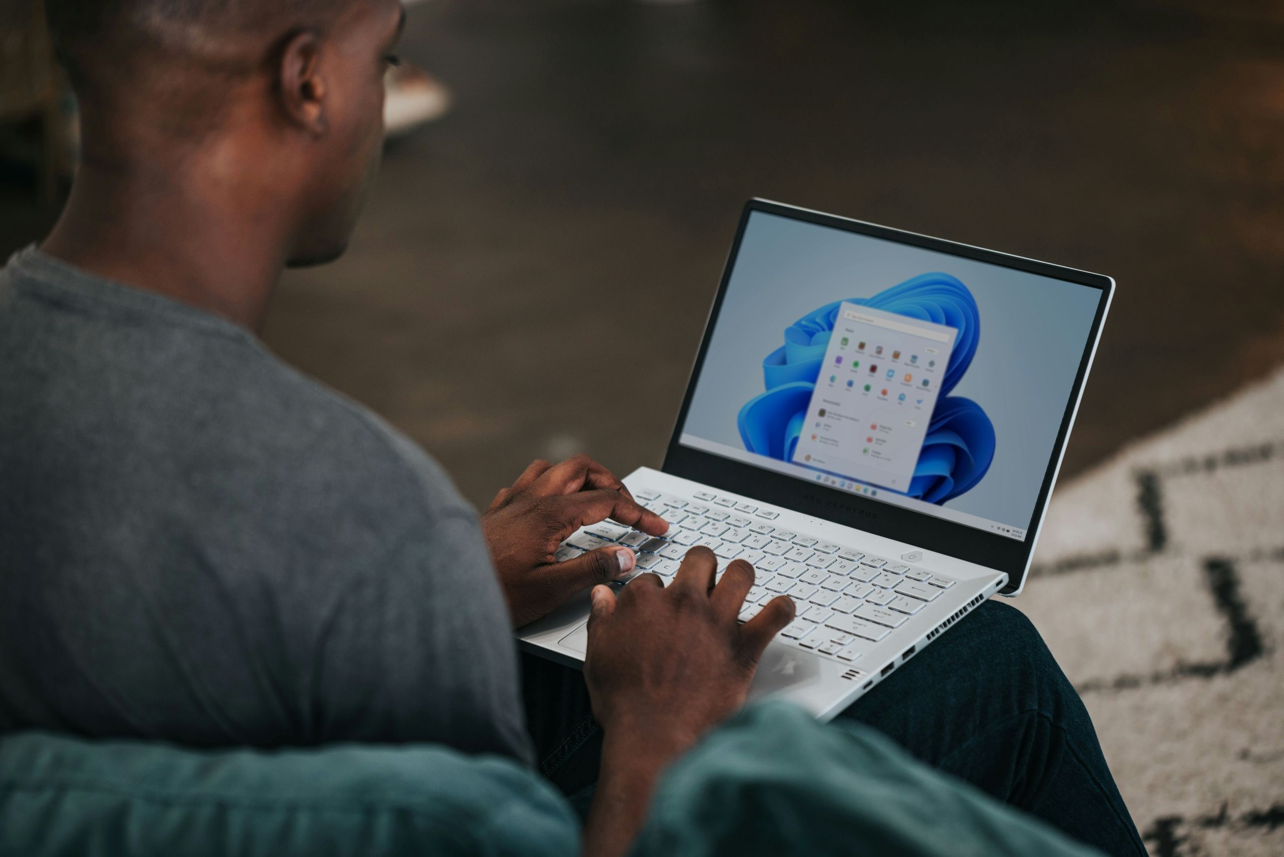 Man using laptop showing Windows user interface.